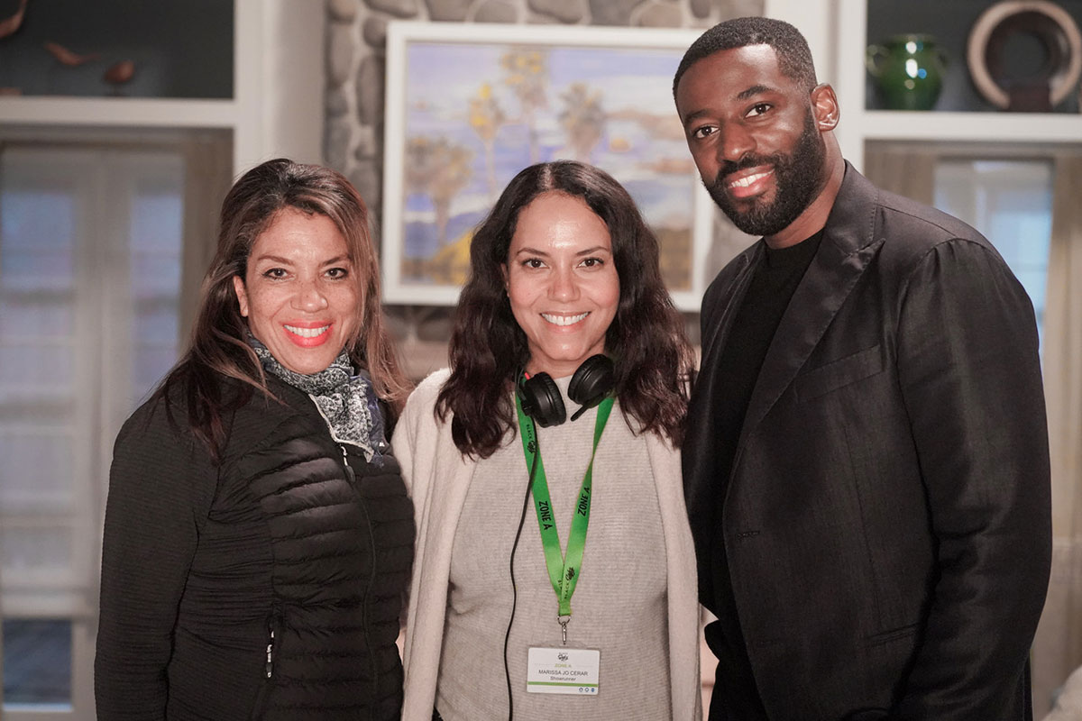 Two women and one man pose smiling